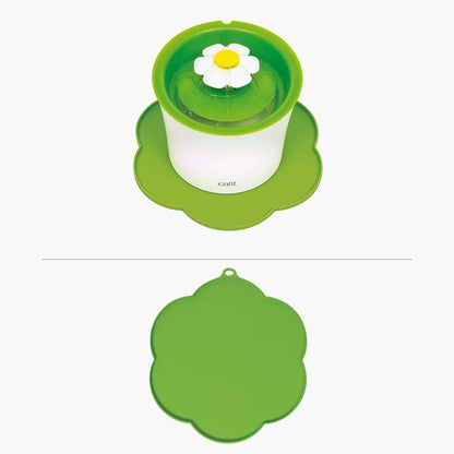 Die grüne "Catit Unterlegmatte BLUME" liegt unter einem Trinkbrunnen.